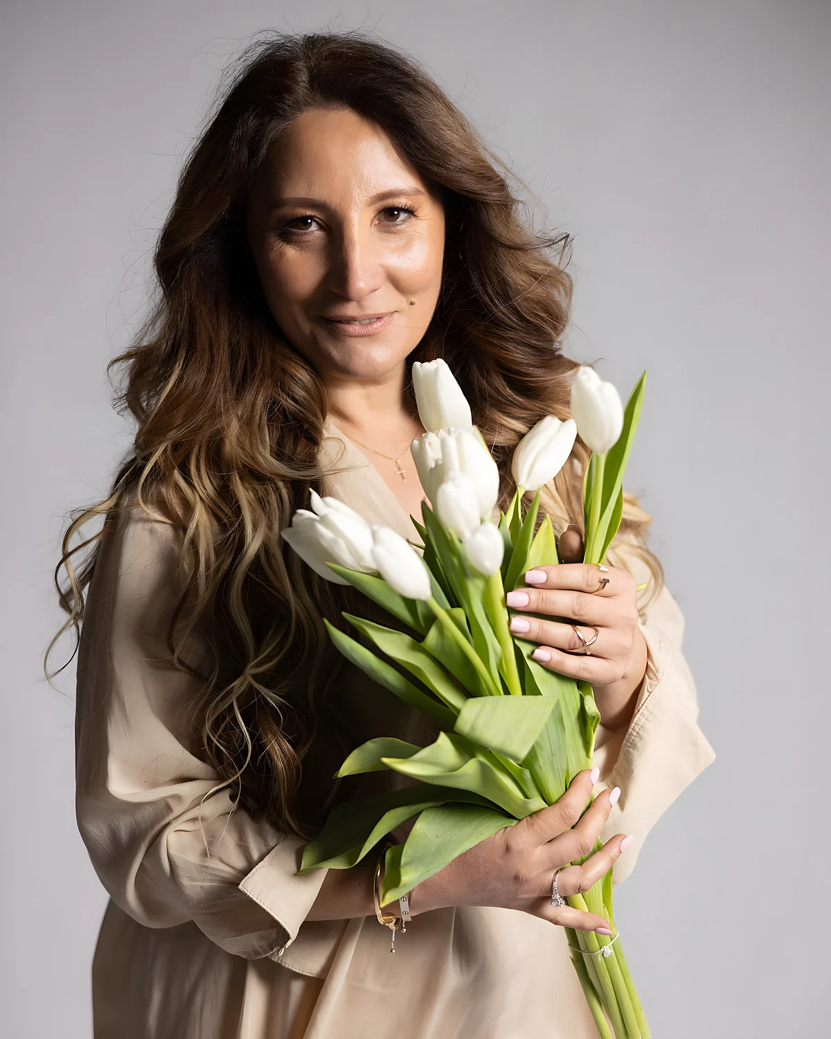 DeLuxe Floral Boutique floral designer holding white tulips