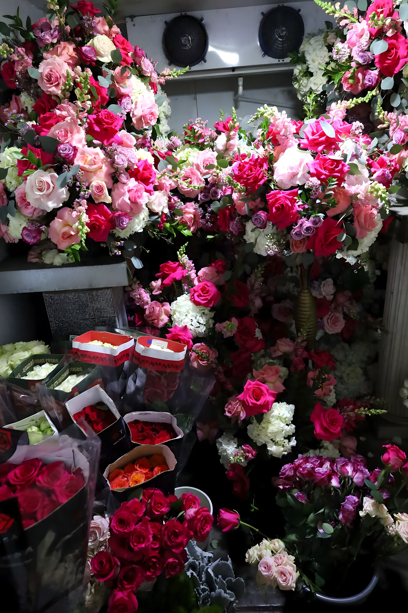 Our flower cooler filled with fresh pink, hot pink and lavender roses and arrangements