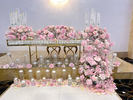 Pink rose floral runner and candles on a reception table