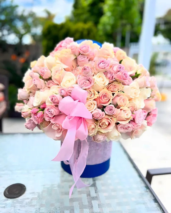 Large dome of pink and peach roses with a pink bow