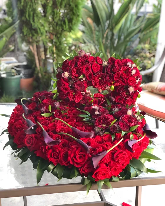 Heart-shaped arrangement of red roses and calla lilies
