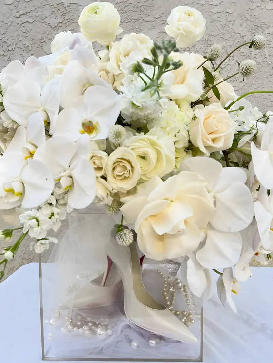 White orchid and garden rose arrangement in an acrylic box