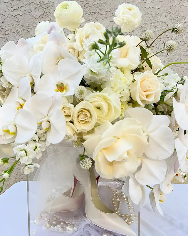 White orchid and garden rose arrangement in an acrylic box