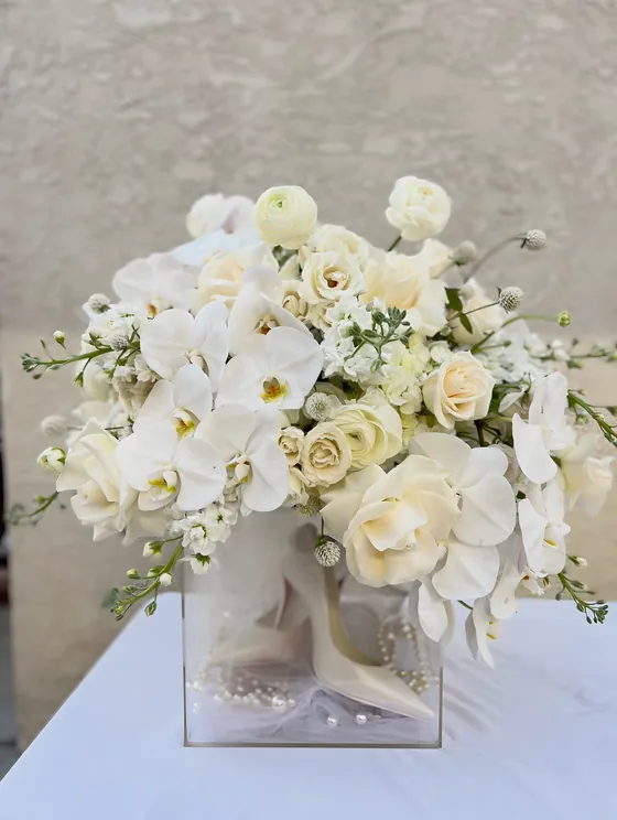 Elegant white roses, orchids and stock in a clear acrylic box